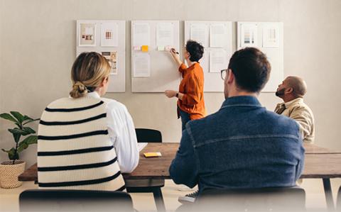 groupe de personnes en formation avec formateur au tableau